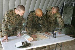 Capt. Quinten Jones, 32, from Memphis, Tenn., looks over a map of Iraq with other members of MITT 3/3 as part of predeployment training in Twentynine Palms, Calif.  the Marines from MITT are scheduled to deploy in February, 2006.