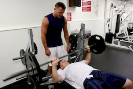 Staff Sgt. Brett Garmon, G-4 air staff noncommissioned officer, U.S. Marine Corps Forces, Pacific, utilizes the bench press and weights, while safely being spotted by Master Sgt. Bill Atwater, G-4 maintenance management chief, MARFORPAC at the  Semper Fit Center here.