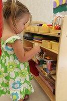Madison Martin, a 2-year-old in the Toddler 1 Classroom at the new Hadnot Point Child Development Center plays in the art section of the room. She curiously digs through a box of toys looking for treasure.