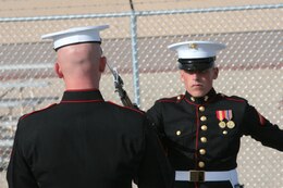 Lance Cpl. Wesley Johnson performs the U.S. Marine Corps Silent Drill Platoon's routine while Cpl. Jeremy Miller, SDP drillmaster, evaluates during Challenge Day at Marine Corps Air Station Yuma, Ariz., Feb. 15.  Johnson would become one of seven rookie marchers in the unit of 24 Marines.