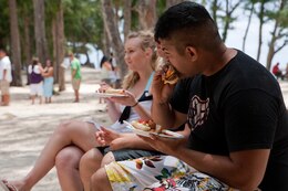 Marines and family members enjoy grilled food on the beach at Bellows AFB June 13 during MarForPac Family day. Family day served as a welcome home to individual augmentees who've deployed with other units last year.