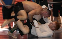 Kyle Stewart slides to his back and brings his opponent crashing toward his guard, finishing the match shortly after with a triangle choke with his legs, during the 2012 US Armed Services Pankration Championship at Camp Horno, May 12.