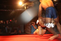 Sgt. Ryan Galvan, a Marine combat instructor with Infantry Training Battalion, School of Infantry-East shoots to take down Cleveland Mclean during Richard Dambakly’s Battle in the South 2 amateur mixed martial arts championship at Hooligan Rub and Music Hall in Jacksonville, Saturday. More than 100 fans attended the event.