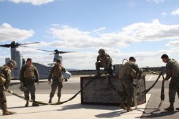 Marines from Landing Support Company, Combat Logistics Regiment 17, 1st Marine Logistics Group, prepare a 1,500 pound cement block to be picked up by a V-22 Osprey, Feb. 17. These blocks are used during training exercises to simulate the cargo that would be shipped while on a deployment.