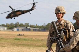 U.S. Marine Corps Lance Cpls. Stephan A. Fournier (left) and Craig J. Reyes (right), both mortarmen with Golf Company, Battalion Landing Team 2nd Battalion 7th Marines, 31st Marine Expeditionary Unit, conduct a weapons drill with a 60 mm mortar as an Australian Blackhawk helicopter takes off behind them on Camp Rocky during Talisman Saber 2011. TS11 is a biennial combined training activity, designed to train Australian and U.S. forces in planning and conducting Combined Task Force operations to improve Australian Defense Force/U.S. combat readiness and interoperability. It reflects the closeness of the alliance and the strength and flexibility of the ongoing military-military relationship.