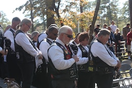 Members of Rolling Thunder Chapter NC-5 bow their heads for a moment of prayer during the 25th annual Beirut Memorial Observance Ceremony, held at the Lejeune Memorial Gardens in Jacksonville, N.C., Oct. 23