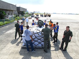 U.S. and Philippine service members load food packs destined for disaster-impacted areas in the southern Philippines, Dec. 9, 2012.