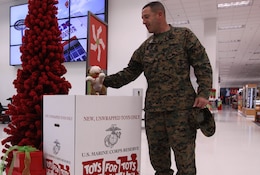 Master Gunnery Sgt. Gary S. Teicher, the ordnance Chief for 1st Marine Division here, places a stuffed animal into a toy donations box at the Marine Corps Exchange here, Dec. 20. Toys for Tots collects donations from October to December, and will reach an estimated 60,000 local, needy children this holiday season.