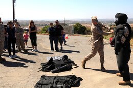Marines of Security Battalion demonstrate the effectiveness of the Fist Suit by swinging a metal bar at the suit during the Jane Wayne Day on Camp Pendleton, June 23. The suit is used for riot control or to escort prisoners who may cause harm to themselves or others.