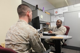 Sgt. Marneze Davis, the lead personal property entitlement counselor at the Distribution Management Office, assists a Marine with submitting a moving in his office aboard Cherry Point March 19. DMO is preparing for peak moving season, this May through September. Davis said he encourages service members to start their moving process as soon as possible to avoid black-out dates.