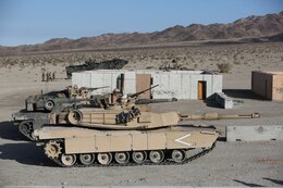 Marines with 1st Tank Battalion assault an urban facility with M1A1 Abrams Tanks during a live fire exercise on Range 210 at Marine Corps Air Ground Combat Center Twentynine Palms, Dec. 6, 2013. The facility resembles an urban environment and is unique because its buildings’ walls are constructed of shock-absorbent concrete. Unlike a majority of urban training facilities, Marines are able to conduct live fire training versus firing blank ammunition.