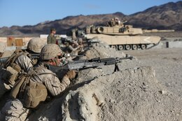 Marines with Alpha Company, 1st Battalion, 7th Marine Regiment, provide security during a live fire exercise on Range 210 at Marine Corps Air Ground Combat Center Twentynine Palms, Dec. 6, 2013. The facility resembles an urban environment and is unique because its buildings’ walls are constructed of shock-absorbent concrete. Unlike a majority of urban training facilities, Marines are able to conduct live fire training versus firing blank ammunition.
