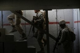 Marines with Alpha Company, 1st Battalion, 7th Marine Regiment, move to the roof of a building to provide security during a live fire exercise on Range 210 at Marine Corps Air Ground Combat Center Twentynine Palms, Dec. 6, 2013. The facility resembles an urban environment and is unique because its buildings’ walls are constructed of shock-absorbent concrete. Unlike a majority of urban training facilities, Marines are able to conduct live fire training versus firing blank ammunition.