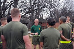 Staff Sgt Jeffrey Helker, faculty advisor, Sergeants Course, Staff Non-Commissioned Officer Academy, speaks with his squad of sergeants after a physical fitness session on Jan. 14. The platoon of sergeants is divided into squads to allow for smaller group discussions. 