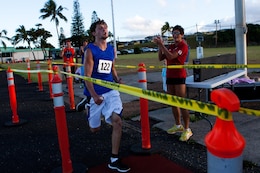 Dallas Giestige, an Ohio native in Oahu for vacation, crosses the finish line of the Camp Smith 5K Grueler first, with a time of 20 minutes, 47 seconds, here July 20. “It was tough,” said the cross-country athlete. “I’m always looking forward to a challenge.” 