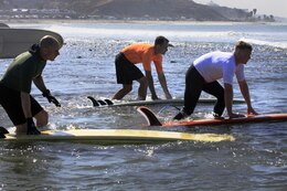 Competitors charge through the water as they take their positions for their turn at the 6th annual 2013 USAA Commanding General's Surf Competition here, June 11. Competitors were split into three categories determined by the length of their board.
