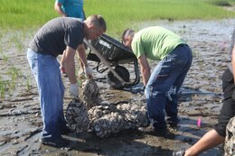 Marines form the Air Station and Parris Islands, gather bags of oysters to lay down at the Laurel Bay shoreline, June 18. Their efforts will bring forth a new oyster environment with three to five years.