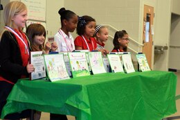 (From left to right) Fairynn Hyde, Geena Rodriguez, Kennedi Holcomb, Hope Gray, Rylee Wood and Krystal Aguilar stand behind their award-winning posters during the annual Earth Day poster contest awards presentation at Elliott Elementary School, April 25. The contest aimed to teach kids more about their environment and with a theme of "Make every day, Earth Day," the top artists were rewarded with a certificate, medal and a gift card to the Marine Corps Exchange.