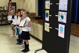 First, second and third place winners from Galer Elementary School's annual Earth Day Poster Contest, stand in front of their award-winning posters during an awards presentation at Galer Elementary, April 25. The contest aimed to teach kids more about their environment and with a theme of "Make every day, Earth Day," the top artists were rewarded with a certificate, medal and a gift card to the Marine Corps Exchange.