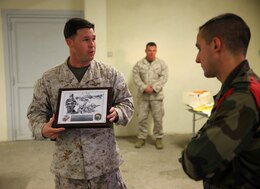 Capt. T. D. McAbee, the air operations officer for Special-Purpose Marine Air-Ground Task Force Crisis Response, presents a plaque to a company commander with the 2nd Foreign Infantry Regiment of France's 6th Light Armored Brigade Oct. 31, 2013, at Camp des Garrigues, France. The event was part of a week-long bilateral training exercise between U.S. Marines with SP-MAGTF Crisis Response and French Legionnaires. SP-MAGTF Crisis Response is a self-mobile, self-sustaining force capable of responding to a range of crises to protect both U.S. and partner-nation security interests in the region, as well as strengthening partnerships throughout the U.S. European Command and U.S. Africa Command area of responsibility. (U.S. Marine Corps photo by Cpl. Michael Petersheim)
