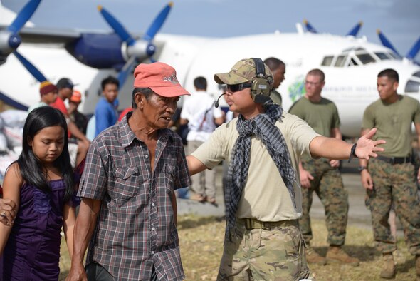 Staff Sgt. Antonio Garcia directs Filipino passengers to the aircraft Nov. 17, 2013, at Guiuan Airport, Republic of the Philippines. Garcia is assigned to the 353rd Special Operation Group as a vehicle maintainer and served as a translator during this mission. Air Force Special Operations Command Airmen are deployed in support of Operation Damayan. (U.S. Air Force photo by Tech. Sgt. Kristine Dreyer) 