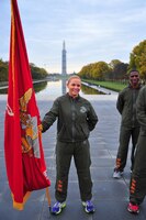 Gunnery Sgt. Tiffany Torres, Advanced Course student at Quantico’s Staff Noncommissioned Officer Academy, holds the Marine Corps flag in front of the reflecting pond with the Washington Monument in the background in Washington, D.C. Nov. 22, 2013.