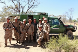 Arnold Beazley (center), a Salvation Army representative known as the Sallyman, and Marines with Marine Rotational Force - Darwin, gather around the Sallyman truck during Exercise Koolendong, here, Sept. 4. Beazley delivers cold beverages and snacks to Australian soldiers and MRF-D Marines during field operations.