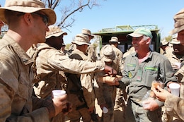 Arnold Beazley, a Salvation Army representative known as the Sallyman, hands out cookies to Marines with Marine Rotational Force - Darwin during Exercise Koolendong, here, Sept. 4. Beazley delivers cold beverages and snacks to Australian soldiers and MRF-D Marines during field operations.