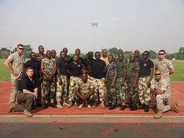 Marines with Special-Purpose Marine Air-Ground Task Force Africa 14.1 and Nigerian soldiers, pose for a photo in Abuja, Nigeria, March 19. The group of four Marines trained approximately 20 Nigerian soldiers on basic non-lethal weapons techniques in support of U.S. Africa Command and Marine Corps Forces Europe and Africa’s theater security cooperation requirements.