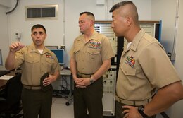 Capt. Odon Garcia, left, avionics officer with Marine Aviation Logistics Squadron 11, speaks to Col. Rick Uribe, center, Marine Aircraft Group 11 commanding officer, and Lt. Col. John DeLateur, MALS-11 commanding officer, during an inauguration ceremony aboard Marine Corps Air Station Miramar, Calif., March 28. The F/A-18 APG-73 Radar System Integrated Test Bench, the logistics squadron’s newest radar repair asset, is slated to save Marines time and money on components to get the systems back on aircraft.

