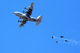 A C-130 drops cargo at an altitude of 1,500 feet during an aerial resupply training procedure with Air Delivery Platoon, Landing Support Company, Headquarters Regiment, 1st Marine Logistics Group, aboard Camp Pendleton, Calif., April 11, 2014. Personnel from Air Delivery Plt. also jumped from the aircraft to meet their quarterly training requirement. These capabilities allow supplies to reach Marines in combat or personnel in a natural disaster when a safe ground route is unavailable.