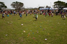 Children dash around a field to collect Easter eggs April 19 at the “Camp Eggstravaganza” outside the Camp Courtney Commissary. Volunteers with groups such as the Single Marine Program, the USO, Navy Federal Credit Union, Camp Courtney Chapel, Community Bank, as well as family readiness officers and Marines provided support for the event. All status of forces agreement personnel were welcome to attend the event. 