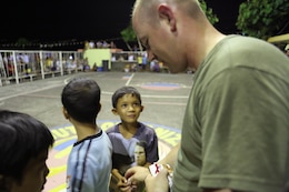 Local children are given candy after a halftime minigame by U.S. Marine Gunnery Sgt. Byron Jacobson at the Barangay Tamaoyan Friendship Basketball Game April 24 during Exercise Balikatan 2014 in Legazpi City, Albay Province, Philippines. Basketball, one of the most popular sports in the Philippines, provided the local community and U.S. service members with the opportunity to interact and get to know one another on a personal level. Balikatan is an annual bilateral exercise between the Armed Forces of the Philippines and U.S. armed forces designed to strengthen interoperability and country-to-country relations. Jacobson is a civil affairs team chief with the Joint Civil Military Operations Task Force, U.S. forces.