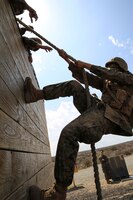 A recruit of Mike Company, 3rd Recruit Training Battalion, climbs a wall during Gonzalez’s Challenge at Marine Corps Base Camp Pendleton, Calif., Aug. 20. Gonzalez’s Challenge is a two-part exercise that requires climbing a wall and swinging from platforms. 