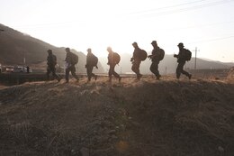 Republic of Korea Marines hike through village outskirts in the Republic of Korea Feb. 2 during a 400-kilometer hike. The ROK Marines in the photo had just completed hiking for the day.  The massive hike spanned 13 days and the Marines hiked an average of 25 kilometers a day.