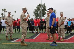 Col. John P. Farnam, left, Marine Corps Air Station Miramar commanding officer, introduces Todd Durkin, owner of Fitness Quest 10, to service members and families during the NFL Football Star Experience aboard Marine Corps Air Station Miramar, Calif., July 15. Durkin led multiple drills and exercises for NFL players during the event. 
