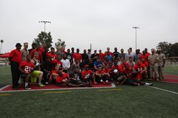 The Miramar Falcons football team poses with NFL players, trainers and Marines for a photo during the NFL Football Star Experience aboard Marine Corps Air Station Miramar, Calif., July 15. Service members and families were able to see NFL players perform various drills and get autographs. 