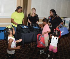 Marine Corps Community Services staff members give school supplies to parents and children at the installation’s Operation Backpack Reload event. The back-to-school bash was held at the Town and Country Restaurant, Marine Corps Logistics Base Albany, July 24.