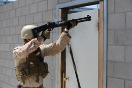 A Marine from 1st Reconnaissance Battalion fires breaching rounds into a door hinge during a Methods of Entry proficiency training exercise aboard Camp Pendleton Calif., June 10.  During the exercise, raid scenarios were tailored for the event to keep the Marines in an operational mindset while honing their skill set for future deployments as the Maritime Raid Force in support of Marine Expeditionary Units. 

