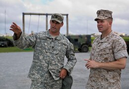 U.S. Army Capt. Owen T. Tolson, left, explains to U.S. Marine Col. Scott F. Stebbins the different positions of the U.S. Army Patriot missile launcher’s setup June 17 at Marine Corps Air Station Futenma. “The joint integration aspect of our unit is really important,” said Tolson, a Dallas, Texas, native. “Our equipment and our operators really rely on the joint community to receive a better understanding of what’s going on in the air and that only helps maximize our capabilities. Receiving more feedback from the joint community really helps our guys so that we’re making informed decisions if we ever did have to process an engagement.” Tolson is an air defense officer with Battery D, 1st Battalion, 1st Air Defense Artillery Regiment, 94th Army Air and Missile Defense Command. Stebbins is a Northglenn, Colorado, native and commanding officer of Marine Air Control Group 18, 1st Marine Aircraft Wing, III Marine Expeditionary Force.
