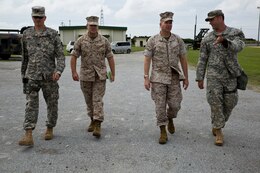 From left to right, U.S. Army Lt. Col. Benjamin R. Ogden, U.S. Marine Lt. Col. Michael D. Hicks, U.S. Marine Col. Scott F. Stebbins and U.S. Army Capt. Owen T. Tolson discuss the U.S. Army Patriot missile launcher’s capabilities and layout June 17 at Marine Corps Air Station Futenma. The Patriot missile launcher’s early warning system helps detect what planes are in the air, identify potential threats and then determine the whether hostile missiles have been launched. Ogden is a Richmond, Virginia, native and battalion commander of Battery D, 1st Battalion, 1st Air Defense Artillery Regiment, 94th Army Air and Missile Defense Command. Hicks is an El Paso, Texas, native and operations officer with Marine Air Control Group 18, 1st Marine Aircraft Wing, III Marine Expeditionary Force. Stebbins is a Northglenn, Colorado, native and commanding officer of the group. Tolson is a Dallas, Texas, native and air defense officer with the battery.