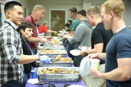 Volunteers serve hungry service members and their families at the No Dough Dinner at the USO of  North Carolina, Jacksonville Center, Feb. 24.
