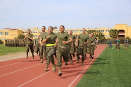 Recruits of Company I, 3rd Recruit Training Battalion, perform the 880-yard run portion of the CFT. Recruits were broken down into groups of 15 and lined up on the track. An instructional Training Company instructor then blew a whistle to signal the start of the event for the first group.