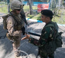Sgt. Mark Anthony V. Awitan, right, a law enforcer in the Philippine Air Force, and U.S. Marine Sgt. Matthew Mahoney, a squad leader with the Fleet Antiterrorism Security Team Pacific, discuss proper procedures for riot control at Clark Air Base during Amphibious Landing Exercise 15, Oct. 1, 2014. PHIBLEX is an annual bilateral training exercise conducted by members of the Armed Forces of the Philippines alongside U.S. Marine and Navy forces focused on strengthening the partnership and relationships between the two nations across a range of military operations including disaster relief and complex expeditionary operations. (U.S. Marine photo by Lance Cpl. Robert Williams Jr.)