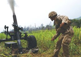 SCHOFIELD BARRACKS, Hawaii – Cpl. Robert Modar, a cannoneer with Charlie Battery, 1st Battalion, 12th Marine Regiment, pulls the lanyard on an M327 Expeditionary Fire Support System Oct. 7 during a training and readiness evaluation. The Marines from 1st Bn., 12th Marines, were getting evaluated on timeliness of getting the 120 mm rounds fired off as preparation for an upcoming deployment. (U.S. Marine Corps photo by Cpl. Erik Estrada)