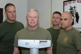 Lt. Gen. Kenneth J. Glueck Jr., Marine Corps Combat Development Command commanding general, center, completes his semi-annual weigh in Aug. 26 under the watchful eyes of his command staff: Maj. Gen. Andrew W. O’Donnell, MCCDC deputy commanding general, left; Col. Timothy S. Mundy, MCCDC chief of staff, back; and Sgt. Maj. Gary W. Weiser, MCCDC sergeant major. Glueck then  monitored his staff’s weigh-ins. A base-wide weigh in is to be completed by all Quantico-based Marines by Sept. 15. (Marine Corps photo by Sgt. Rebekka S. Heite/Released)