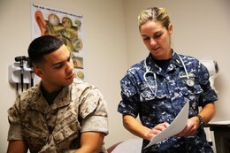 Second Lt. Elias M. Cabrera, left, listens to medical advice from Navy Lt. Tayler B. Eldridge during a routine appointment at the Naval Health Clinic, Marine Corps Air Station Cherry Point, N.C., Sept. 23, 2014. 
NHCCP reorganized treatment systems recently to better provide for Marines, Sailors, military dependents and retirees who seek medical care at the facility. The new Medical Homeport streamlines appointment scheduling and healthcare services, and ensures individuals and family units receive the highest quality care available through a comprehensive appointment based system.
Cabrera is an air traffic control officer with Headquarters and Headquarters Squadron and a native of Orlando, Fla. Eldridge is a naval flight surgeon assigned to NHCCP and is a native of Santa Cruz, Calif. 