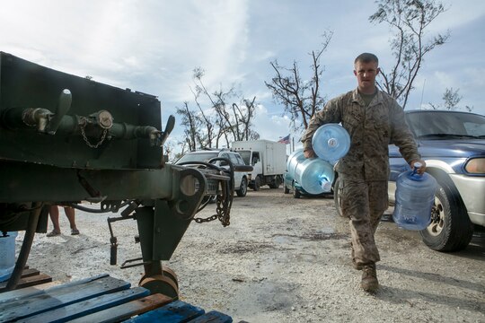 U.S. Marine Pfc. Michael Hundley, with Combat Logistics Battalion 31, 31st Marine Expeditionary Unit, carries empty water jugs for local civilians during typhoon relief efforts in Saipan, Aug. 14, 2015. The Marines with Echo Company, Battalion Landing Team 2nd Battalion, 5th Marines, 31st MEU and CLB 31, 31st MEU, assisted the locals of Saipan by producing and distributing potable water. The Marines and sailors of the 31st MEU were conducting training near the Mariana Islands when they were redirected to Saipan after the island was struck by Typhoon Soudelor Aug. 2-3. (U.S. Marine Corps photo by Lance Cpl. Brian Bekkala/Released)