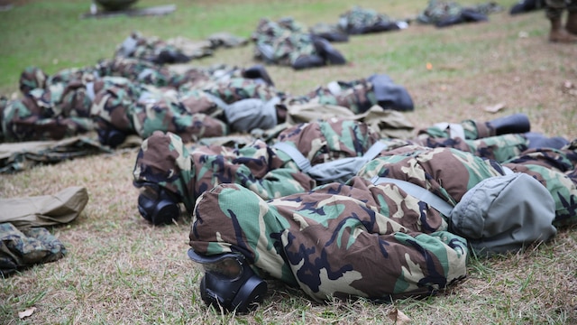 Marines with 2nd Transport Support Battalion lie in the prone position during a nuclear explosion simulation during chemical, biological, radioactive and nuclear defense training held at Marine Corps Base Camp Lejeune, N.C., Dec. 1, 2015. Marines applied information obtained in classes about an active chemical threat and the proper protective equipment to decontaminate themselves in a CBRN situation.