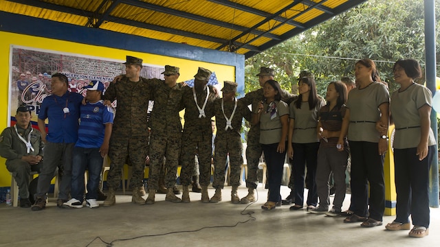 U.S. Marines and the teachers and staff of Concepcion Elementary School sing together during an intermission at the ribbon cutting ceremony Oct. 8, during Amphibious Landing Exercise 2015 in Puerta Princesa, Philippines. PHIBLEX is an annual, bilateral training exercise conducted by members of the Armed Forces of the Philippines alongside U.S. Marine and Navy Forces. It focuses on strengthening the partnership and relationships between the two nations across a range of military operations, including disaster relief and complex expeditionary operations. The ribbon cutting ceremony signified the end of the Humanitarian Civic Assistance projects at the Concepcion and Binduyan Elementary schools. (U.S. Marine photo by Cpl. Robert Williams Jr./Released)